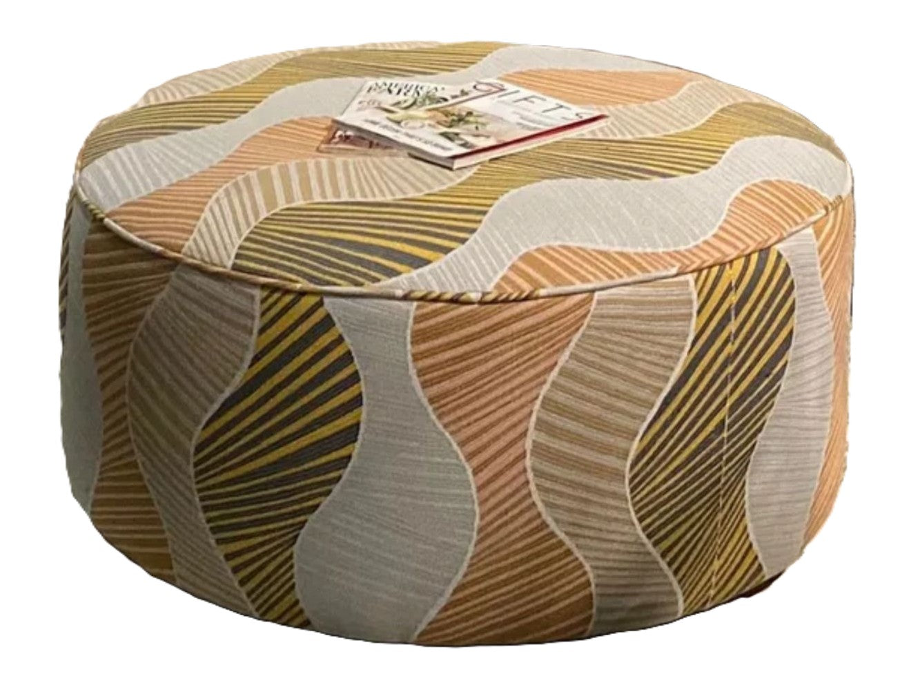 A round cocktail ottoman with a padded top upholstered in a wavy abstract fabric in gold, blush, and natural colors.