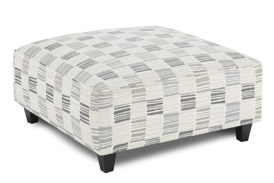 A large cocktail ottoman with fabric upholstery in a modern check pattern in shades of slate bluegray grayand white.